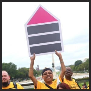 A man hold up a Fair Housing Sign at the My Medicaid Matters Rally