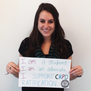 NCIL Policy Intern Ashton Rosin holds the sign - I am a student, I am an advocate, I support CRPD Ratification