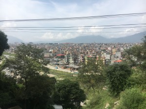 View of Kathmandu - a bustling city with multi-colord buildings and mountains in the distance