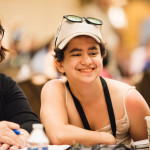 Three young people smile while sitting together at a table at the 2016 Annual Conference on Independent Living