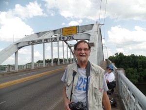 Image: Tom Olin stands on the Edmund Pettus Bridge. 