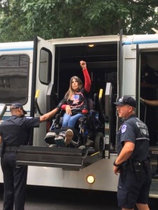 ADAPT member Dawn Russell raises her first in power as she is loaded on to a police vehicle