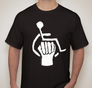 Black t-shirt with Disability Power emblem on front center. Emblem is a white wheelchair accessibility symbol with a stylized raised fist in the center.