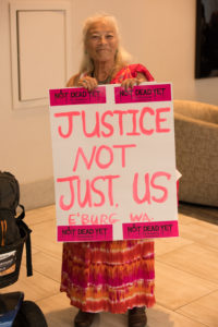 A NCIL Member holds a sign that reads "Justice Not Just Us" at the 2017 Annual Conference on Independent Living