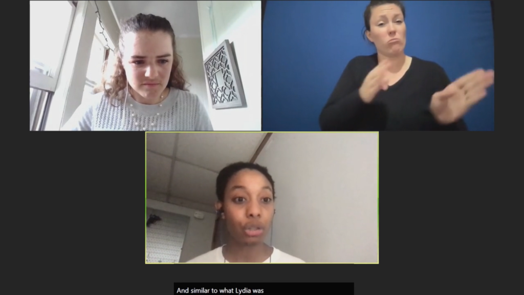 Screenshot of Zoom call with three participants taking part. One is speaking at the camera. One person is signing using ASL. One person is listening. 
